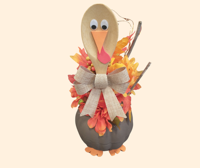 Tabletop turkey craft with a mixing spoon face, styrofoam pumpkin body, and fall floral picks for the tail